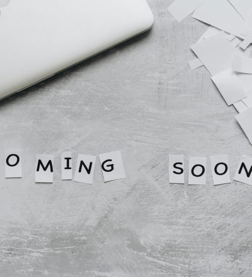 A creative arrangement with paper cutouts spelling 'Coming Soon' on a textured surface.